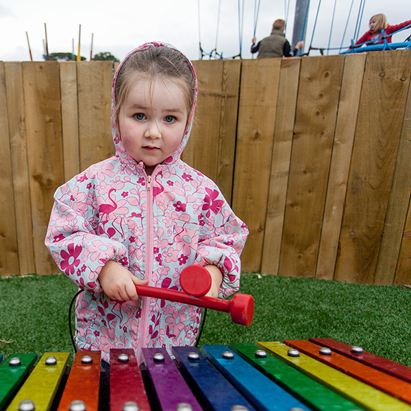 little girl playing a large outdoor musical instrument in the new playground at Greystones Co Wicklow Ireland