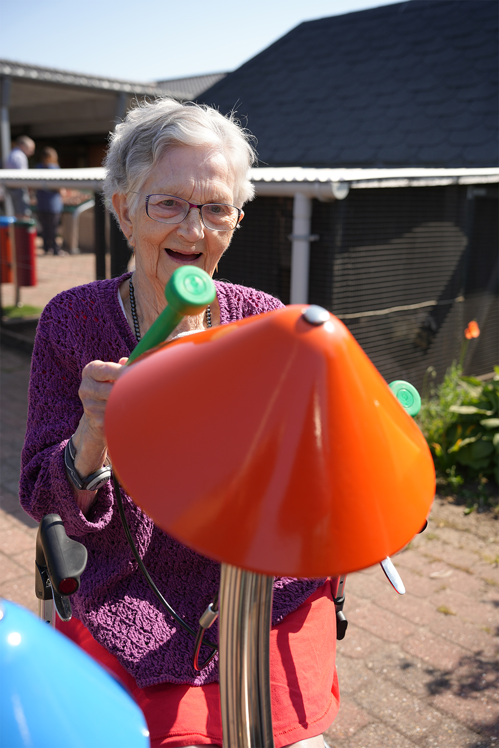 senior lady playing outdoor musical bells in a senior living home