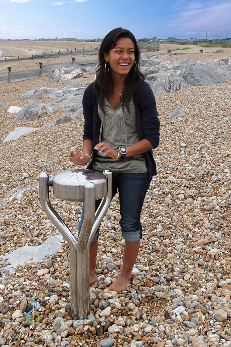 Teenage Girl Playing Stainless Steel Outdoor Tongue Drum on Beach