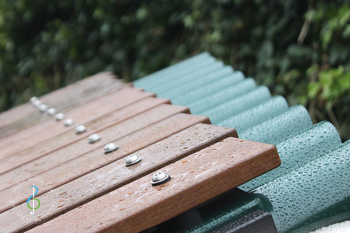 close up of wet timber notes of large outdoor xylophone 