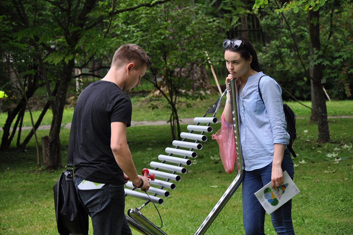 Young couple in a park playing a large outdoor musical instrument