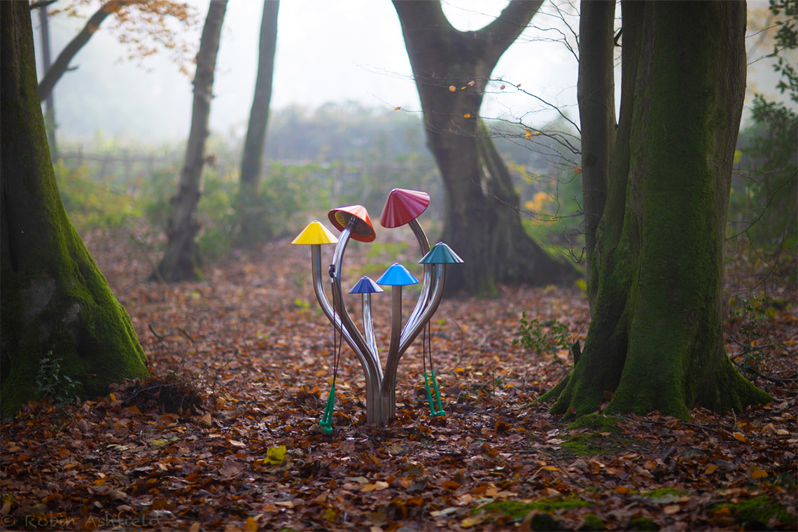 outdoor musical chimes in a woodland shaped like colourful cluster of mushrooms