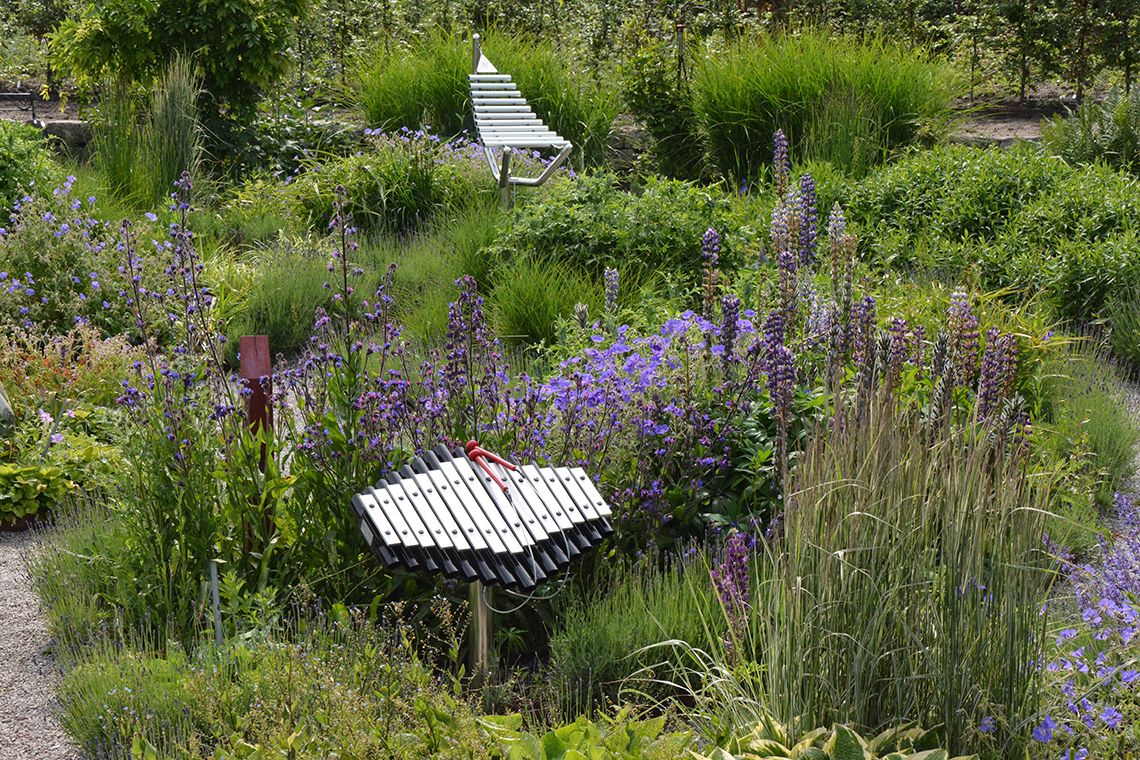 outdoor xylophone nestled among plants and flowers in a sensory garden